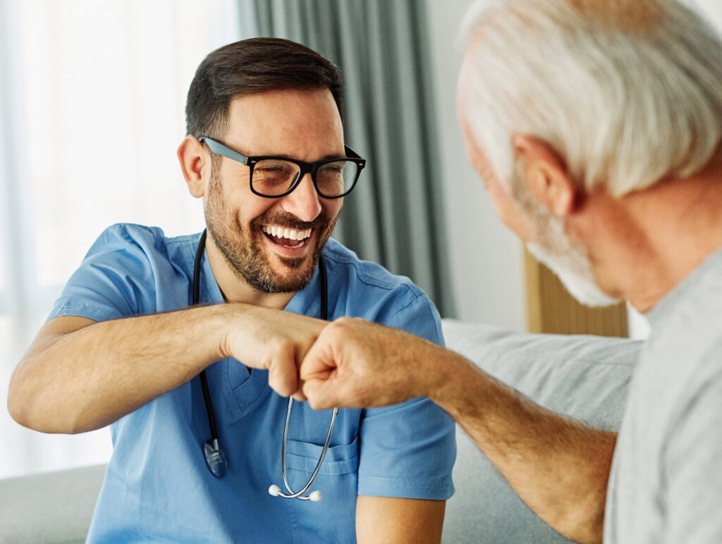 Krankenschwester Arzt Seniorenbetreuung Betreuerin Hilfe Assistenz Faustgruß Geste Hand Altersheim Pflege Senioren Gesundheit Unterstützung Teamarbeit Mann